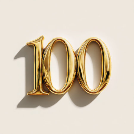 A gleaming golden number one hundred, casting a soft shadow on a clean surface. This image is perfect for representing milestones, anniversaries, and celebratory achievements.の素材
