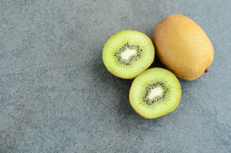 Whole and sliced kiwi fruit on stone backgroundの写真素材