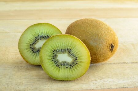 Upclose whole and sliced kiwi fruit on wooden backgroundの写真素材