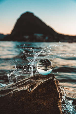a beautiful reflection of an ocean and mountain in a glass ballの写真素材