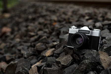Vintage Camera kept on stones at the side of a railway track with selective focusの写真素材