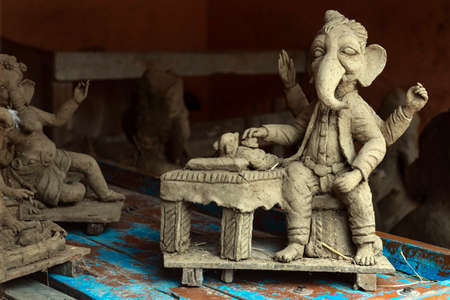 Creative closeup of unfinished clay & hay model of Lord Ganesh\Ganesha wherein he is holding modak, his favorite sweet with his hands. Ganesh chaturthi is the first hindu festival of the yearの写真素材