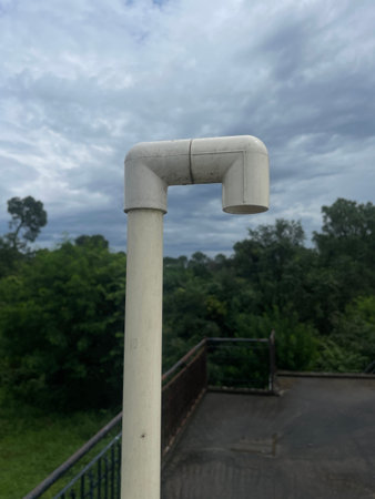 Single white plastic pipe in open blue sky