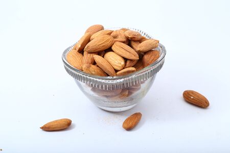 Almonds in glass bowl on white backgroundの写真素材