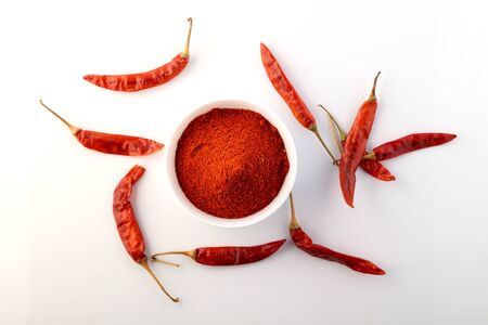 Red chillies with red chilly powder on white background.の写真素材