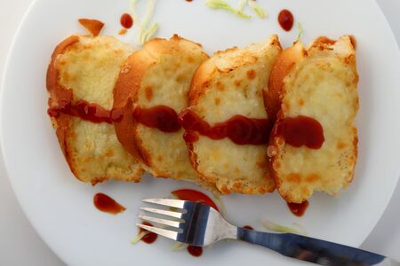 Garlic and herb bread slices with tomato sauce in white plate.の写真素材