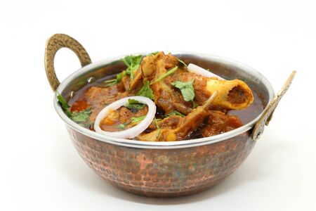 Indian meat dish or mutton curry in a copper brass bowl.の写真素材