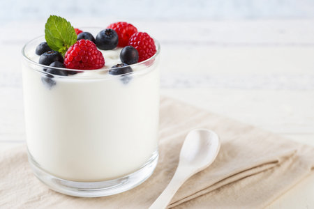 Yogurt with berries and mint in a glass on a wooden backgroundの素材
