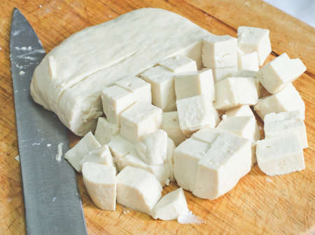 Raw tofu cut in dices on wooden board の写真素材