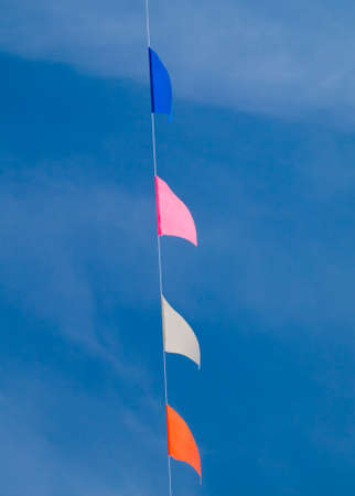 Colored triangular flags on blue sky backgroundの写真素材