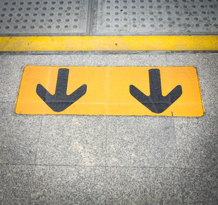Arrow sign on floor at the sky train