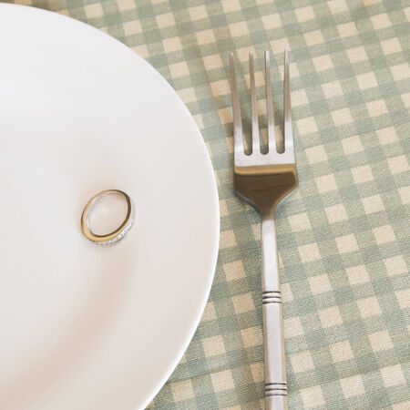 wedding rings on plate with forkの写真素材