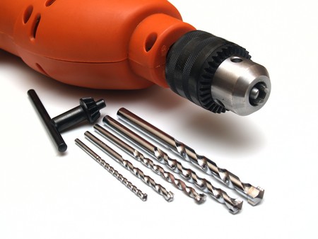 head electric drill with a set of drill bits on white background      