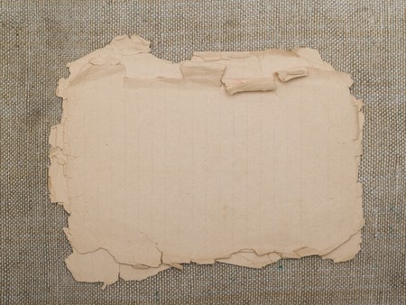 very old yellowed paper on an old cloth backgroundの写真素材