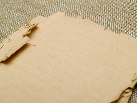 very old yellowed paper on an old cloth backgroundの写真素材
