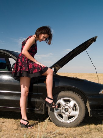 Young woman repairing a car, unscrew the wheelの写真素材