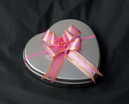 Gift box in the shape of a heart with a pink bow