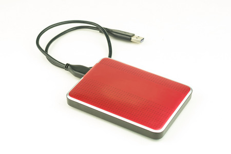 Red external hard drive with usb cable on the white background.