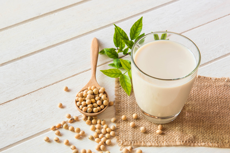 Soy milk in glass and soy been on spoon it on white table background,healthy concept.の写真素材