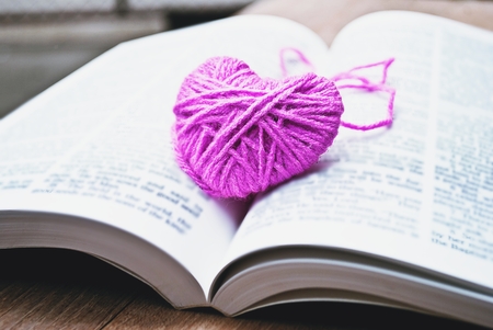 pink heart knitting wool put on the bookの写真素材