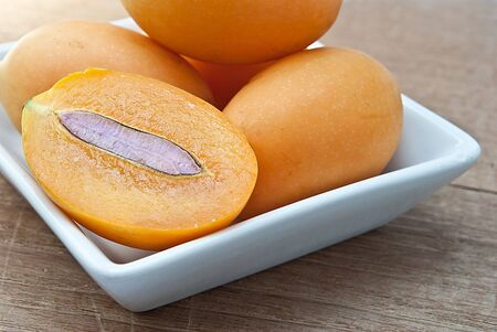 Sweet Marian plum fruit in bowl on wooden background Mayongchid Maprang Marian Plum and Plum Mango,thailand.の写真素材
