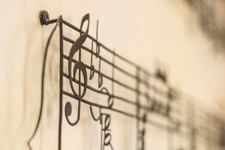 "G Clef" old steel on the old wall with music note blur on background, vintage styleの写真素材