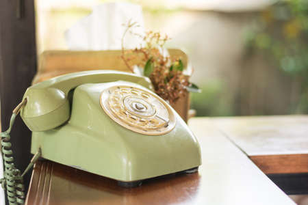 still life old green telephone on old wooden backgroundの写真素材