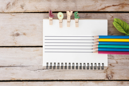 multicolor pencil, vintage book and love text on the wooden, valentine's day for backgroundの写真素材