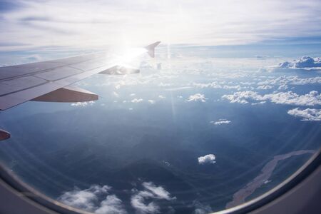 View of beautiful clouds and wing of airplane from window, view of through window aircraft during...