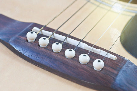Close-up of acoustic guitar bridge in vintage style