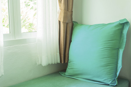 light green pillow near in glass window with soft light in the morningの写真素材