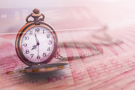 pocket watch over yuan banknotes with double exposure effect, time is money, business and finance conceptの写真素材