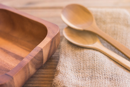 Empty wooden bowl and spoon on old wooden background