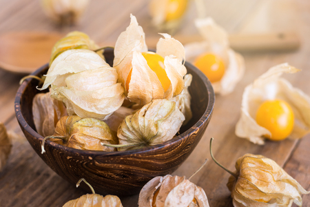 Cape gooseberry (Physalis) in wooden bowlsの写真素材
