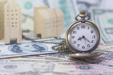 Classic pocket watch and home model on dollar banknote, concept and idea of time value and money, realestate business and finance concepts.の写真素材