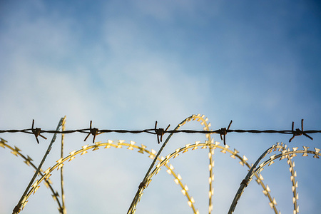 Barbed Wire Fence Used For Protection Purposes Of Property And Imprisonment, No Freedom, Barbed Wire On fence With Blue Sky To Feel Worrying.の写真素材
