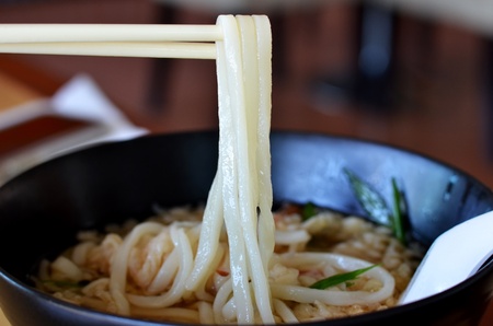 Udon noodle on chopsticks , noodle with shrimp tempuraの写真素材