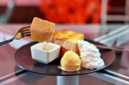 close up toast  on fork , toast and whipping cream with vanilla ice cream  served with honey sauceの写真素材
