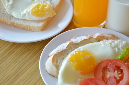 american style breakfast , with toast,  fried egg and fresh vegetables , milk and orange juiceの写真素材