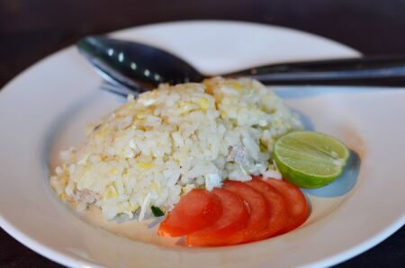  fried rice  served with tomato and lemon on white dishの写真素材