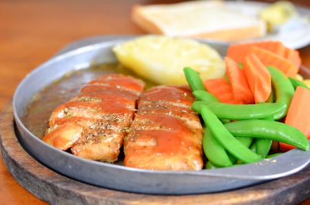 roasted fish  and tomato sauce served with vegetableの写真素材
