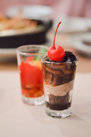 a layered chocolate , garnished with cherries in glassの写真素材