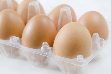 brown eggs in the package on white backgroundの写真素材