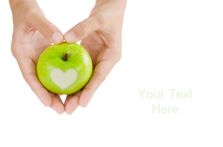 hand and green apple with  heart shape on white backgroundの写真素材