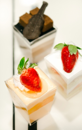 cheese cake with  strawberries,  decorated with fresh strawberries and chocolate , served in a bowl with a smallの写真素材