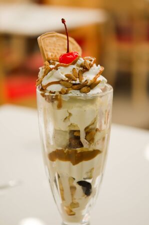 Vanilla ice cream in bowl with almond  , caramel sauce and cherry ,の写真素材