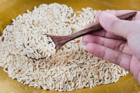 wooden spoon  with uncooked  rice grains  の写真素材