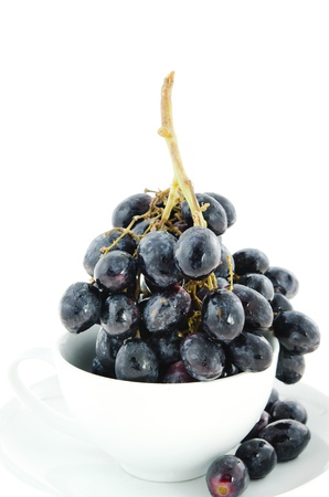 black grapes  fruits in white bowl  over white backgroundの写真素材