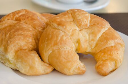 close up two croissants on white dishの写真素材
