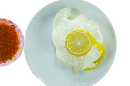 fried egg with fresh lime  on white dish and chili sauce の写真素材